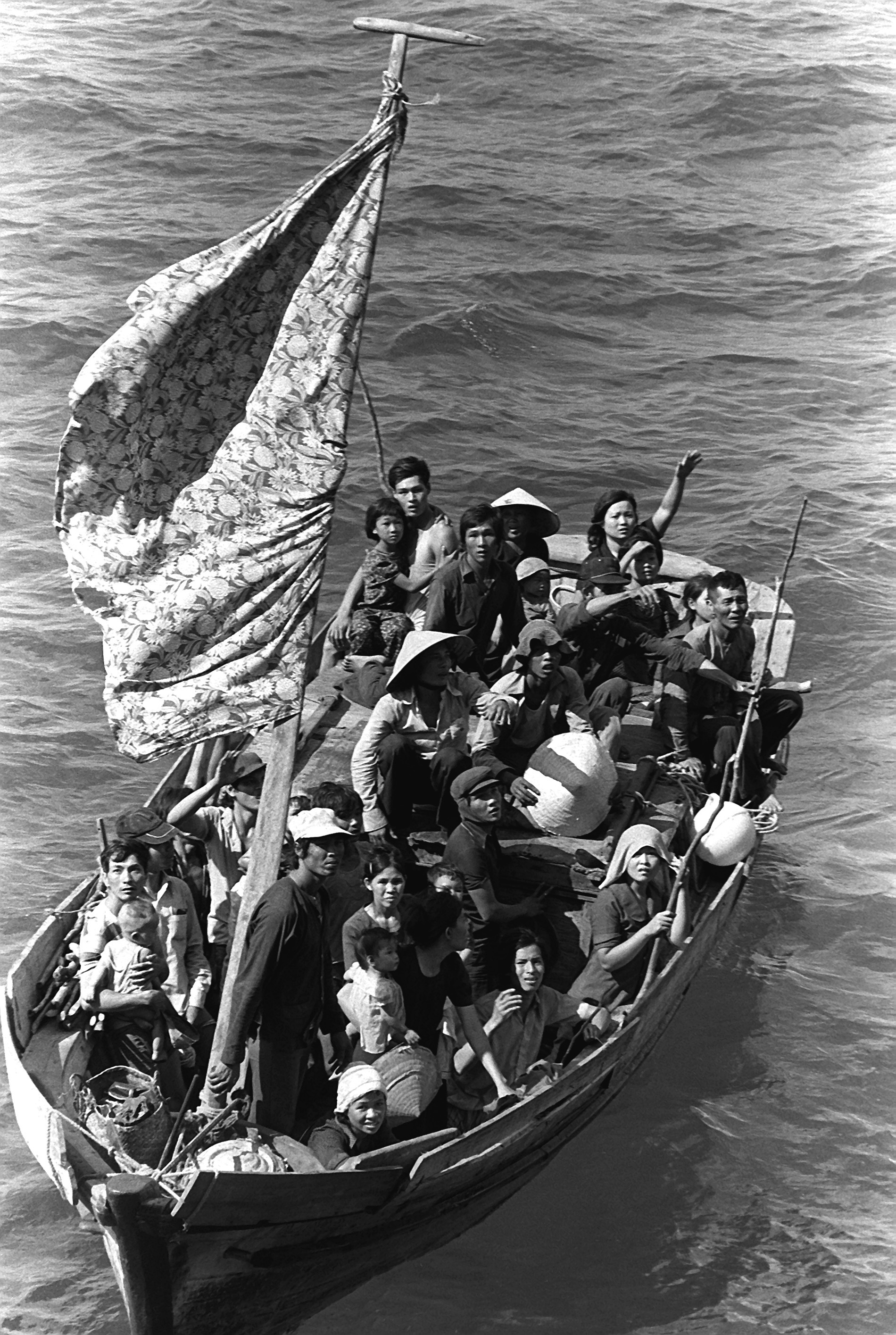35 Vietnamese refugees wait to be taken aboard the amphibious command ship USS BLUE RIDGE (LCC-19). They are being rescued from a 35 foot fishing boat 350 miles northeast of Cam Ranh Bay, Vietnam, after spending eight days at sea.
